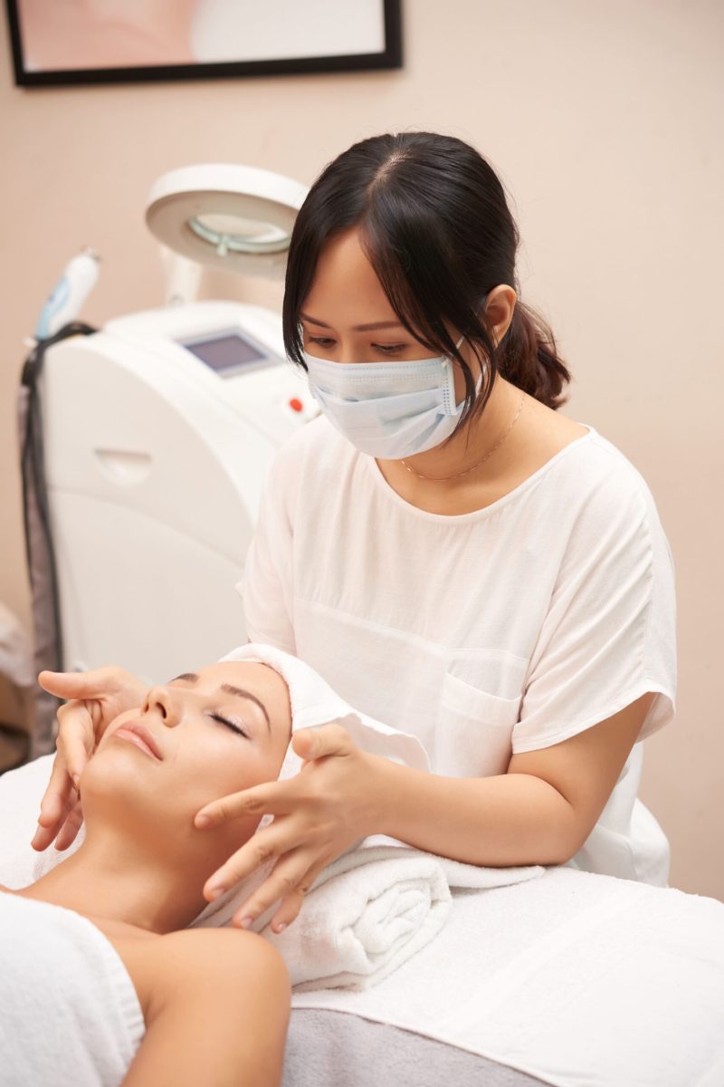 asian-cosmetician-giving-caucasian-client-face-massage (1)